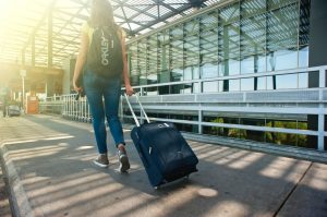 Kvinde går med kuffert i lufthavn