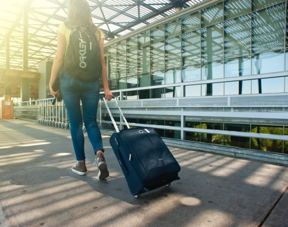Kvinde går med kuffert i lufthavn